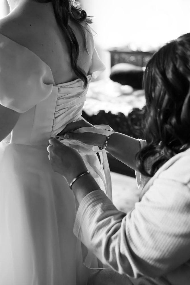 Bride having her wedding dress laced up